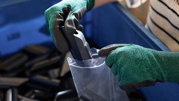 service-ersatzteile ASS-Mitarbeiterin verpackt Bodenschoner in Montagebeutel