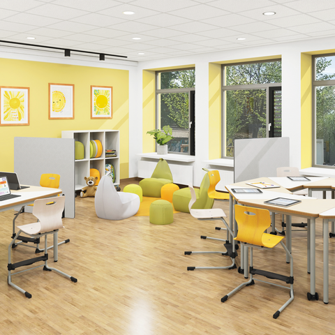 Klassenraum einer Grundschule mit gruppierten Dreieckstischen, Sitzsäcken und zonierenden Trennwänden