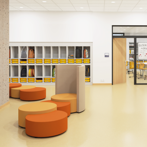 Durchgangsbereich zu Klassenräumen mit Garderobenschränken und einer Sitzgruppe aus Polsterelementen