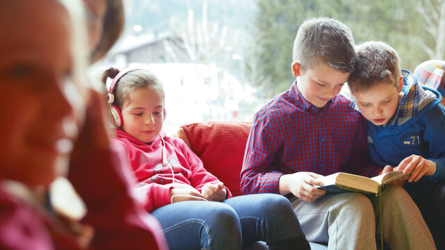 rueckzug Ein Mädchen sitzt mit Kopfhörern auf einer Couch