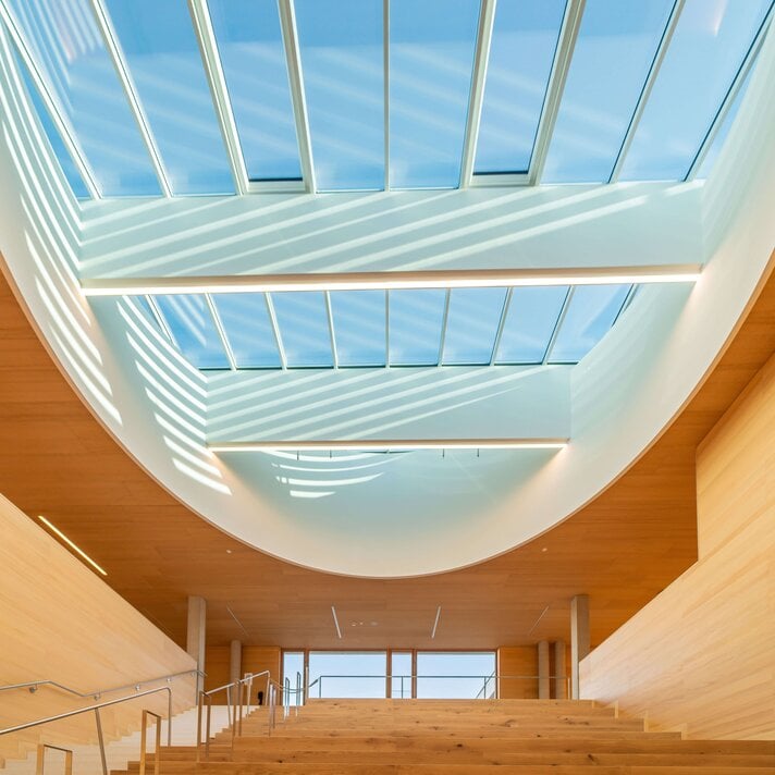 Dachluke über der Sitztreppe im Eingangsbereich der Volksschule Wals-Siezenheim.